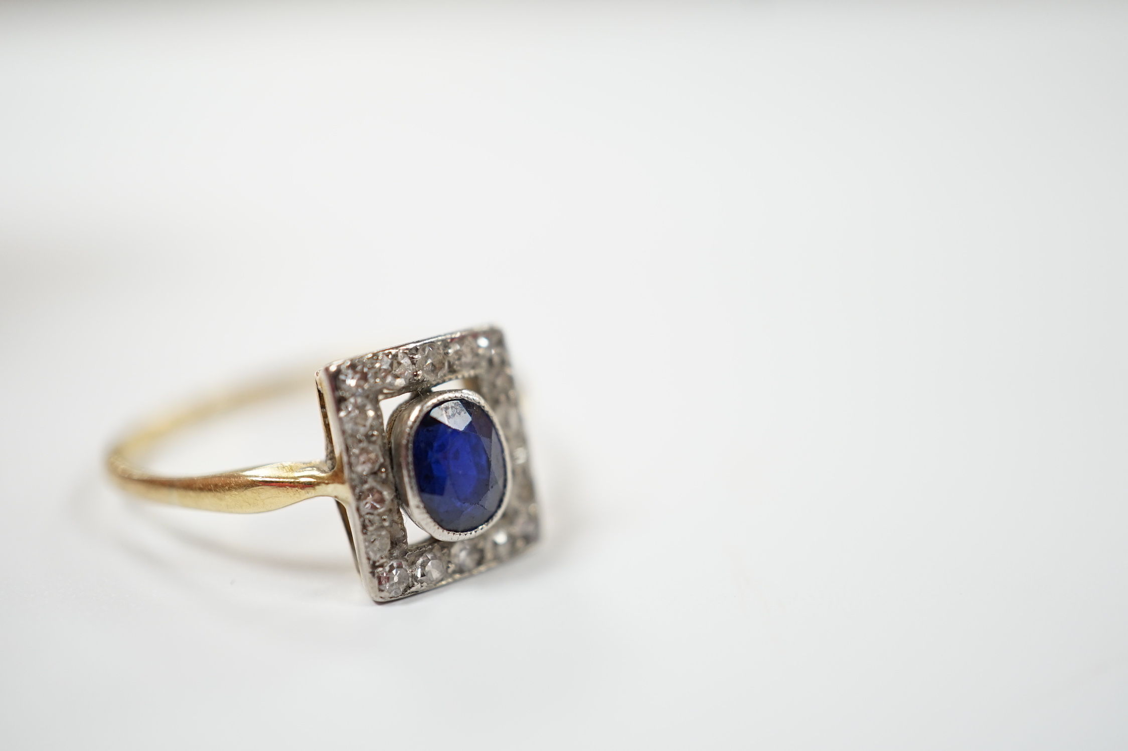 A yellow metal, sapphire and diamond cluster set tablet ring, size P, gross weight 2.3 grams.